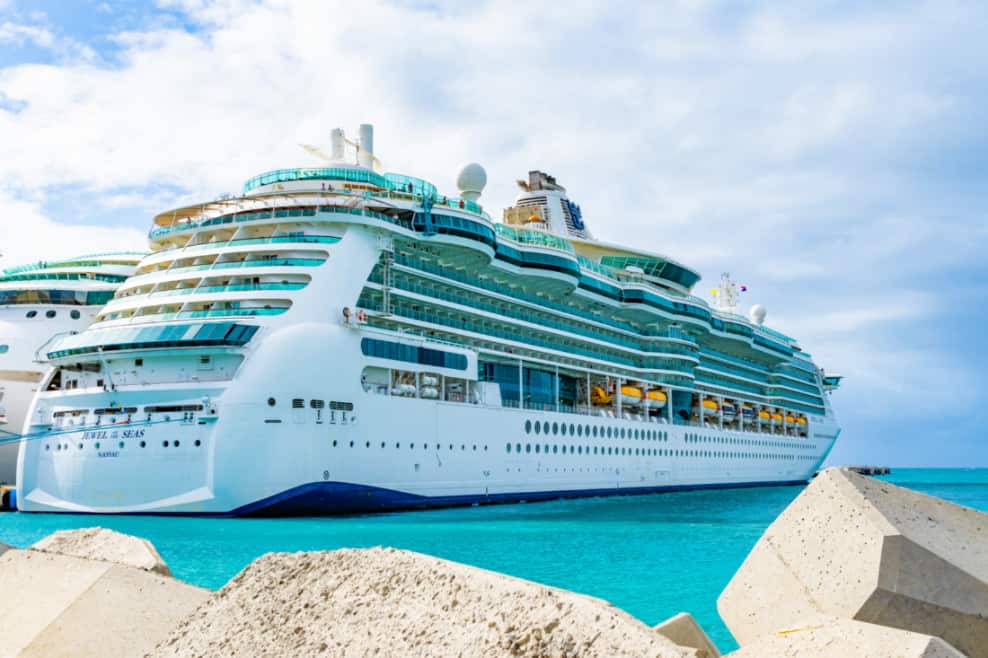 A Travel Advisor observing a large cruise ship docked at a dock. by Chasing the Sun Vacations