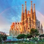 The sagrada familia in barcelona with a rainbow in the sky. by Chasing the Sun Vacations