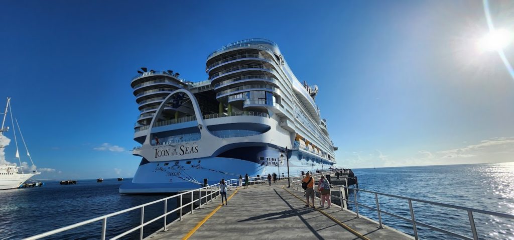 A large cruise ship docked at a dock. by Chasing the Sun Vacations